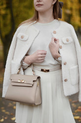 A lady wears a white crop coat on Thanksgiving day.